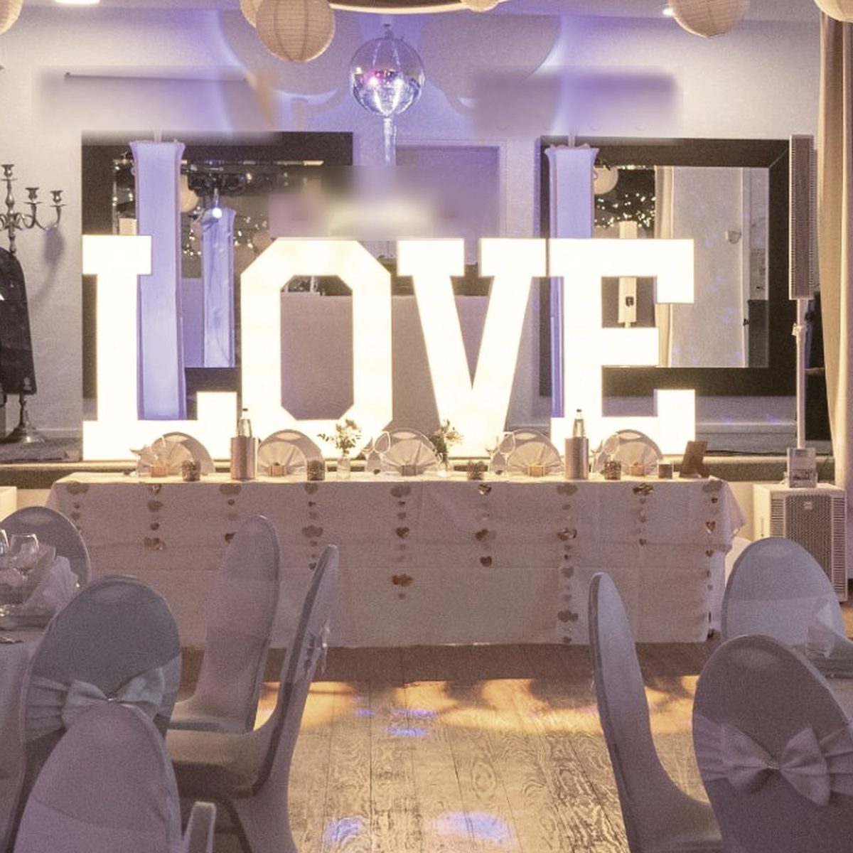 Illuminated white LOVE letters in a wedding hall
